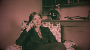 Virginia Woolf sentada em um sofá.